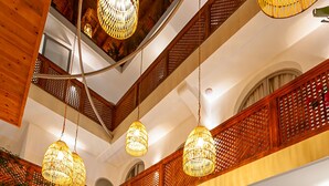 A spacious indoor swimming pool with a tiled floor, surrounded by wooden railings and hanging wicker lamps. - Riad Dar Bayane (Marrakech)