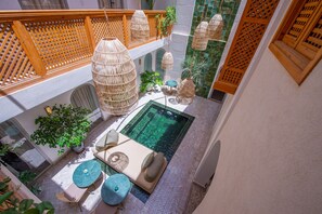 A rooftop pool area with a seating arrangement, hanging wicker lamps, and a view of the pool. - Riad Dar Bayane (Marrakech)