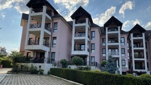 A multi-story residential building with balconies, a paved courtyard, and well-maintained landscaping. - Stunning 2-bed Apartment in sea Resort Varna (Varna)