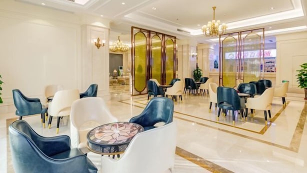 A spacious lobby with modern seating arrangements, a decorative glass partition, and elegant lighting fixtures. - Vienna International Hotel (Gaoxin Keji Road Metro Station Store) (Xi'an)