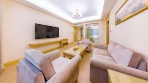 A modern living room with a flat-screen TV, two sofas, a coffee table, and a chandelier. - Vienna International Hotel (Gaoxin Keji Road Metro Station Store) (Xi'an)