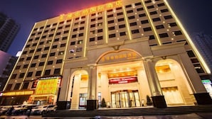 A multi-story hotel with a prominent entrance and illuminated signage. - Vienna International Hotel (Gaoxin Keji Road Metro Station Store) (Xi'an)