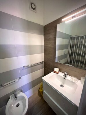 Deluxe kamer | Badkamer | Een douche, een regendouche, gratis toiletartikelen, een haardroger