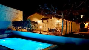 A nighttime view of a swimming pool area with a patio and a small building. - Gite des écureuils, sea view, private pool, parking, air conditioning (La Ciotat)