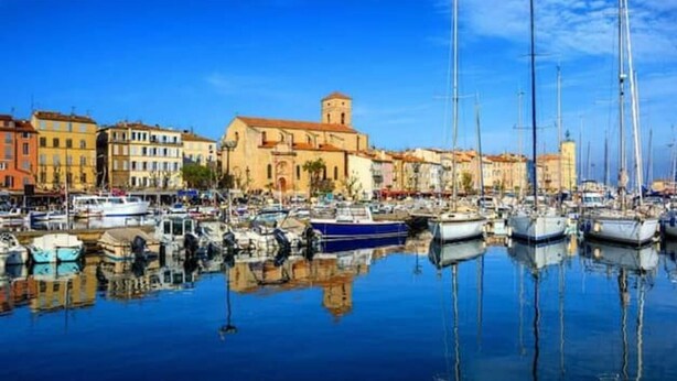 A marina with multiple boats docked, a prominent church with a bell tower, and colorful buildings along the waterfront. - Gite des écureuils, sea view, private pool, parking, air conditioning (La Ciotat)