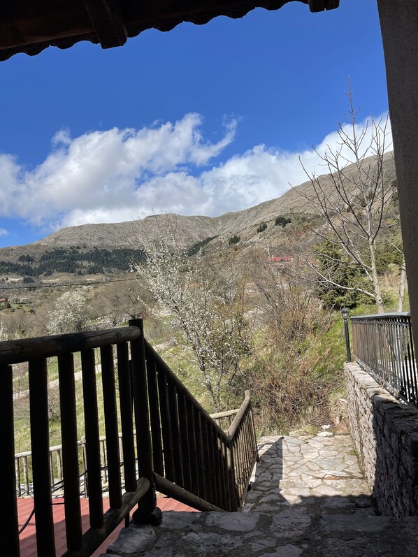 Una escalera de piedra que lleva a un balcón con vistas a un paisaje montañoso.