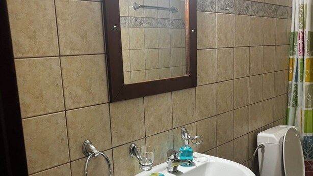 Un baño con un lavabo blanco, un espejo y un inodoro.