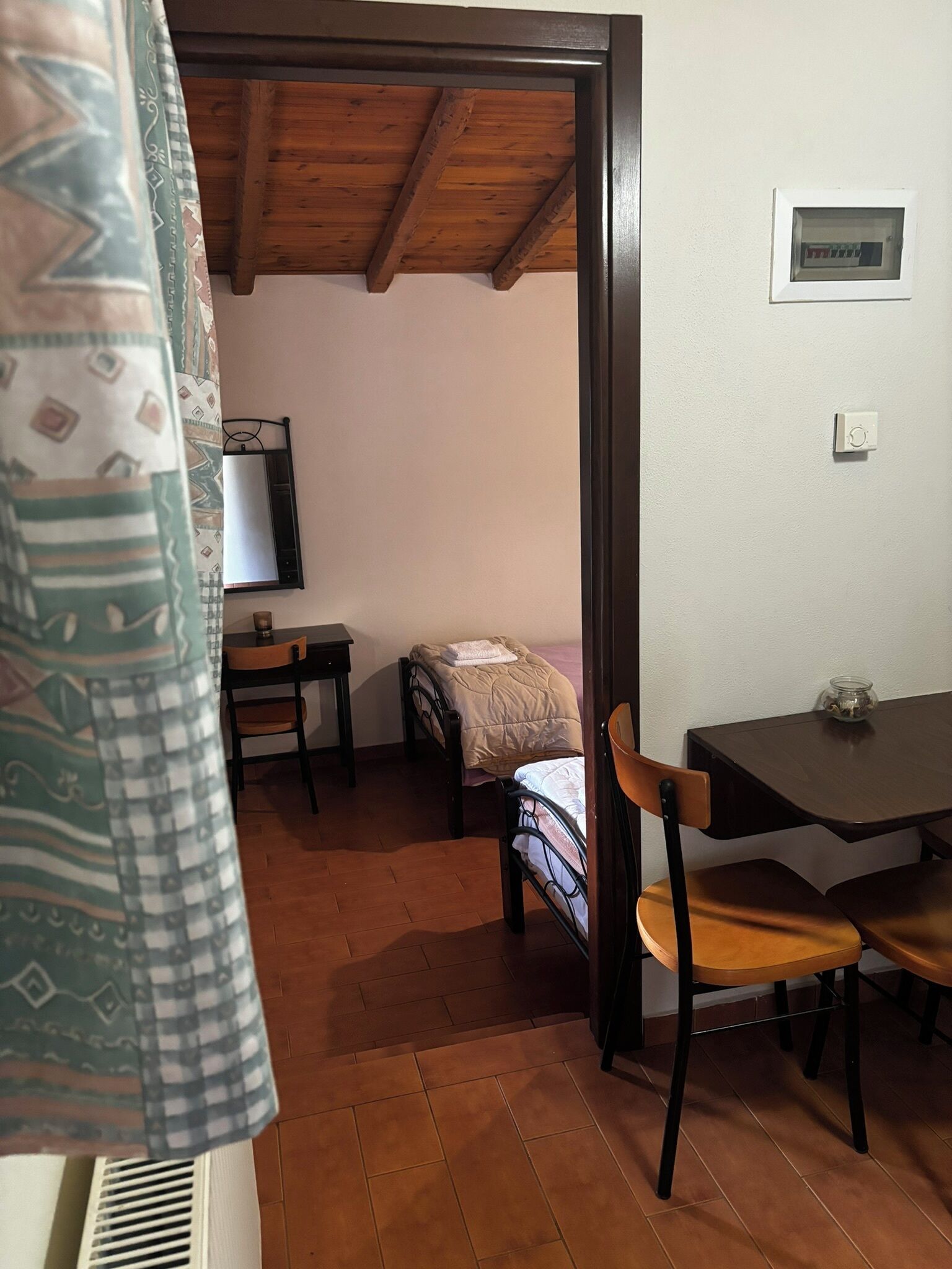 A room with a bed, a table, a chair, and a window.