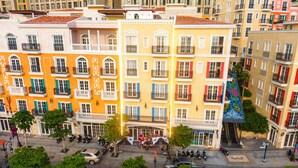 A multi-story building with balconies, a coffee shop, and a blue bus. - Royal Hotel Phú Quốc (Phu Quoc)