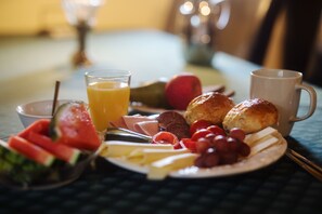 A breakfast setting with a plate of food, a glass of orange juice, and a cup. - Akaciegaarden Bed & Breakfast (Harlev)