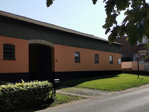 A building with a large arched entrance, a number '14' on the wall, and a mailbox. - Akaciegaarden Bed & Breakfast (Harlev)