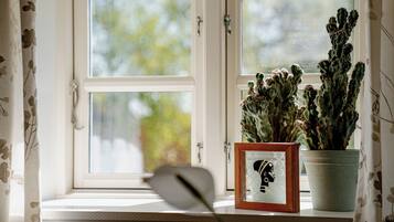 Una ventana con una planta de cactus y un cuadro en el alféizar.