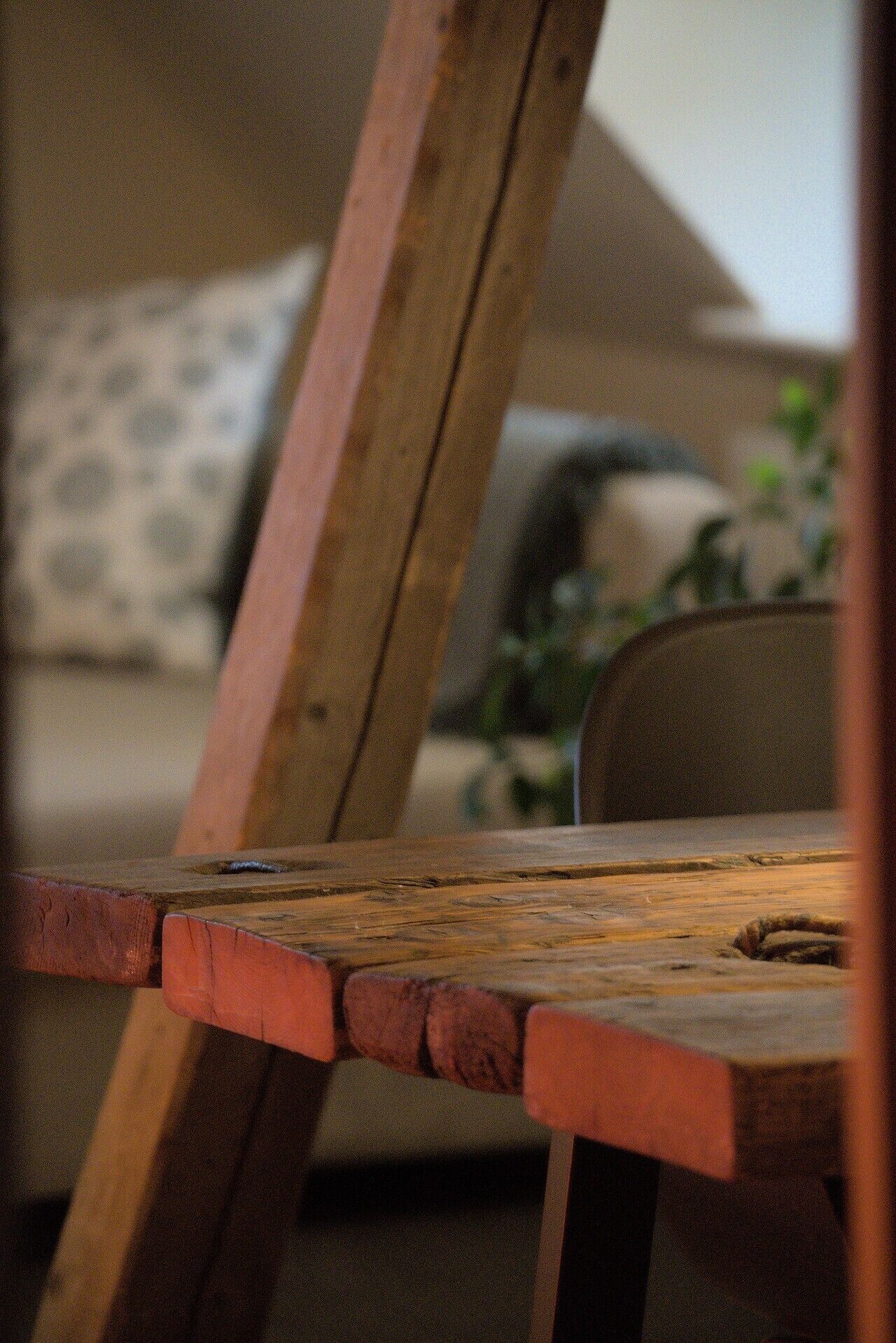 A wooden chair with a visible wear and tear on the seat.