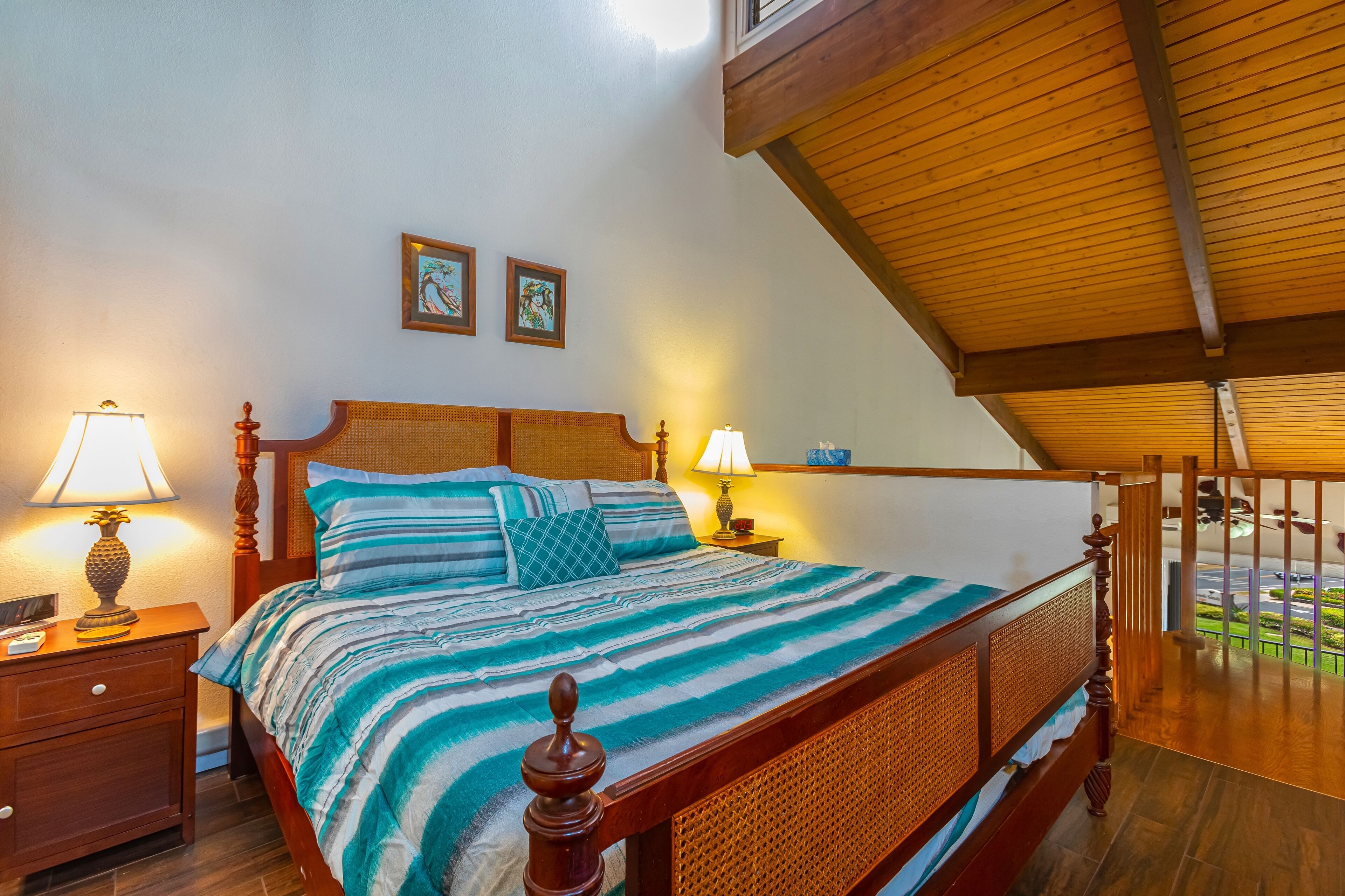 A bedroom with a wooden bed, two bedside lamps, and a view of the outdoors.