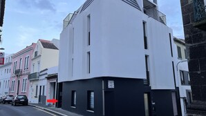 Un edificio moderno con fachada blanco y negro, un techo inclinado y un pequeño balcón.