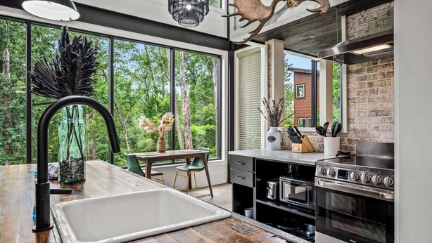 A modern kitchen with a large window, wooden flooring, and a built-in oven. - Your own pool! Sauna, Theater, Top 1% (Gatlinburg)