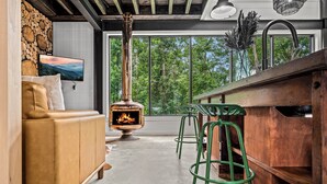 A cozy living area with a fireplace, a sofa, and a bar area with stools. - Your own pool! Sauna, Theater, Top 1% (Gatlinburg)