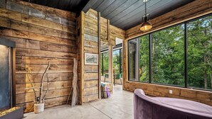 A modern interior with wooden walls, large windows, and a seating area. - Your own pool! Sauna, Theater, Top 1% (Gatlinburg)