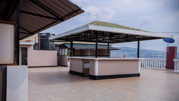 Terraço no telhado com área de estar coberta, antena parabólica e vista para a paisagem urbana.