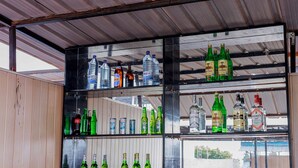 Uma área de bar com prateleiras repletas de garrafas e latas.