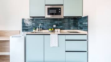 Comfort studio (Twin) | Privékeuken | Een broodrooster, een kookplaat, kookgerei, borden en bestek