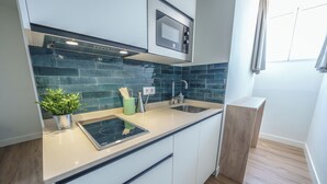 Une cuisine moderne équipée d’un four à micro-ondes encastré, d’un évier et d’une cuisinière.