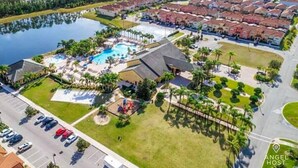 An aerial view of a resort with a swimming pool, multiple buildings, and a parking lot. - Screened Pool & Themed Rooms 8 Miles to Disney (Kissimmee)