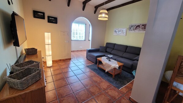 A living room with a sofa, a coffee table, a TV, and a lamp. - Large, cozy holiday apartment just 70 m from the beach (La Caleta de Interián)