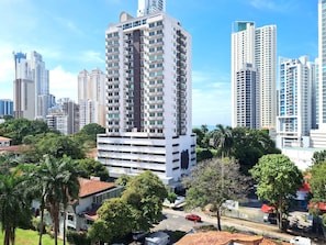 Stylish high-rise building surrounded by lush greenery and urban amenities.