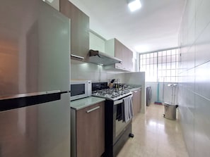 Enjoy cooking in this well-equipped kitchen with a microwave, gas stove, and range hood.