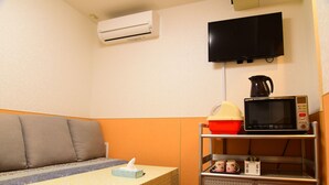 A small kitchenette with a microwave, coffee maker, and storage cabinets. - Ueno House VIP (Tokyo)