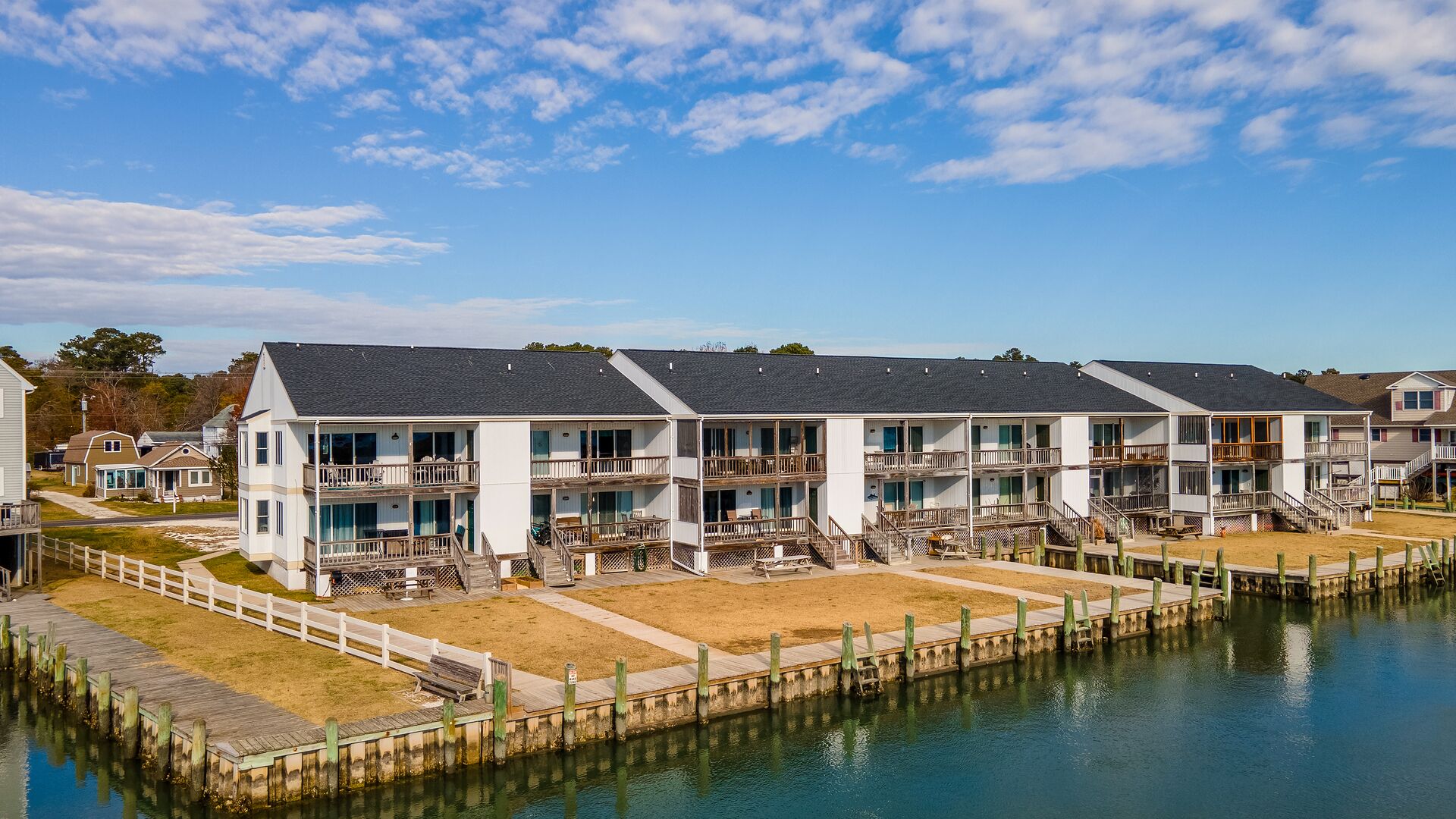 A waterfront hotel with multiple balconies, a dock, and a clear view of the water.