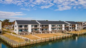 A waterfront hotel with multiple balconies, a dock, and a clear view of the water.