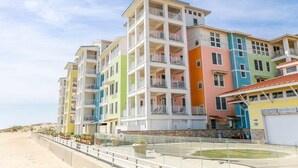 A multi-story hotel with balconies, located near a beach. - Sojourn Sanctuary Seaside Escape (Virginia Beach)