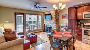 A modern living room with a fireplace, dining area, and kitchen. - Beautiful Condo Central to Main Street and Peak 9! (Breckenridge)