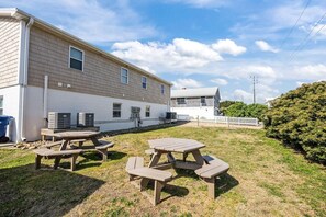 A residential property with a large house, outdoor seating area, and a fenced yard. - Boardwalk Shores C 3 Bedroom Duplex by RedAwning (Atlantic Beach)
