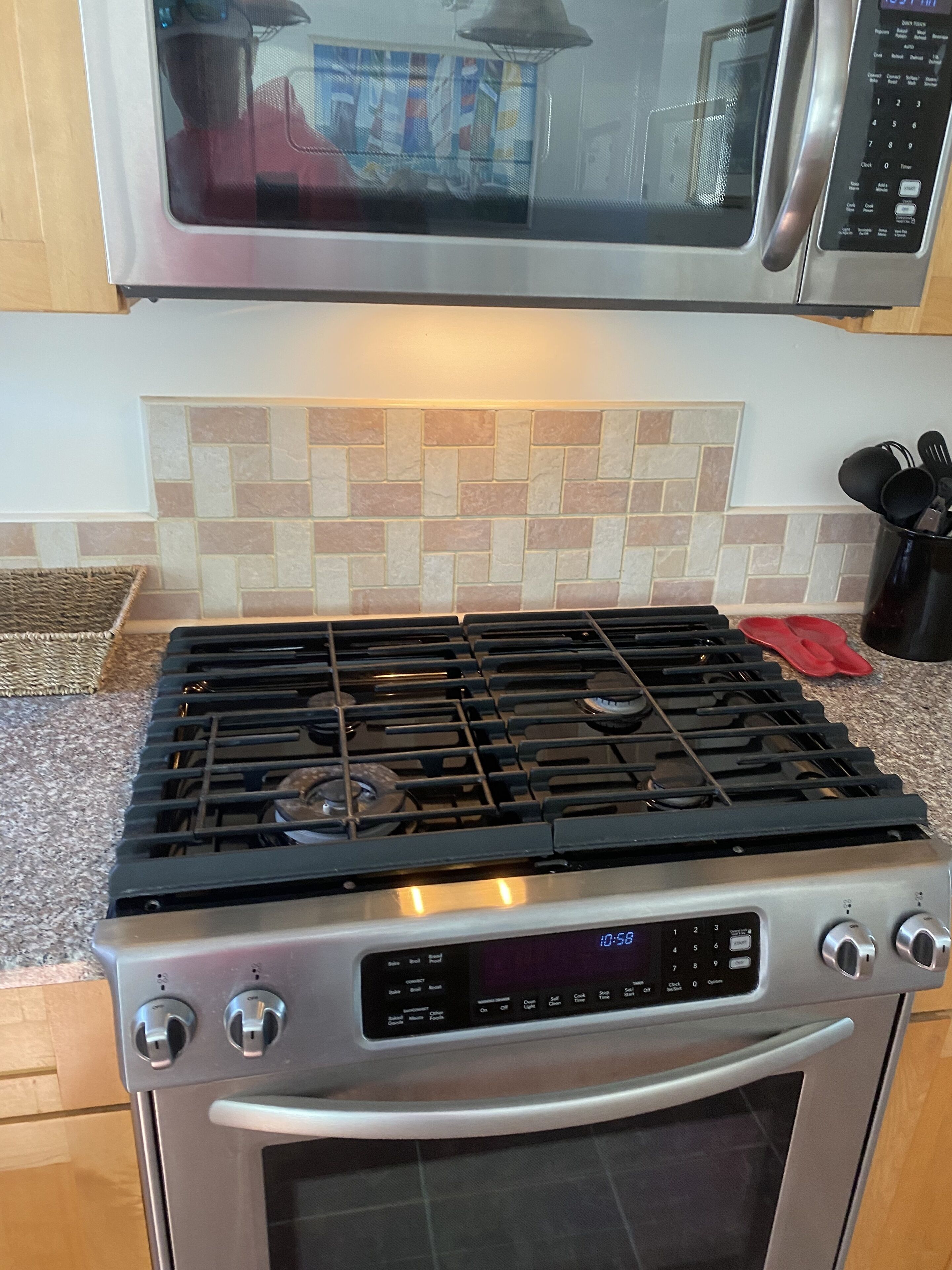 Una cocina equipada con estufa a gas, horno y microondas.