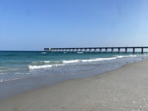 A beach with a pier extending into the ocean. - Big and Beautiful Coastal Retreat with a view from the top balcony!!! (Wrightsville Beach)