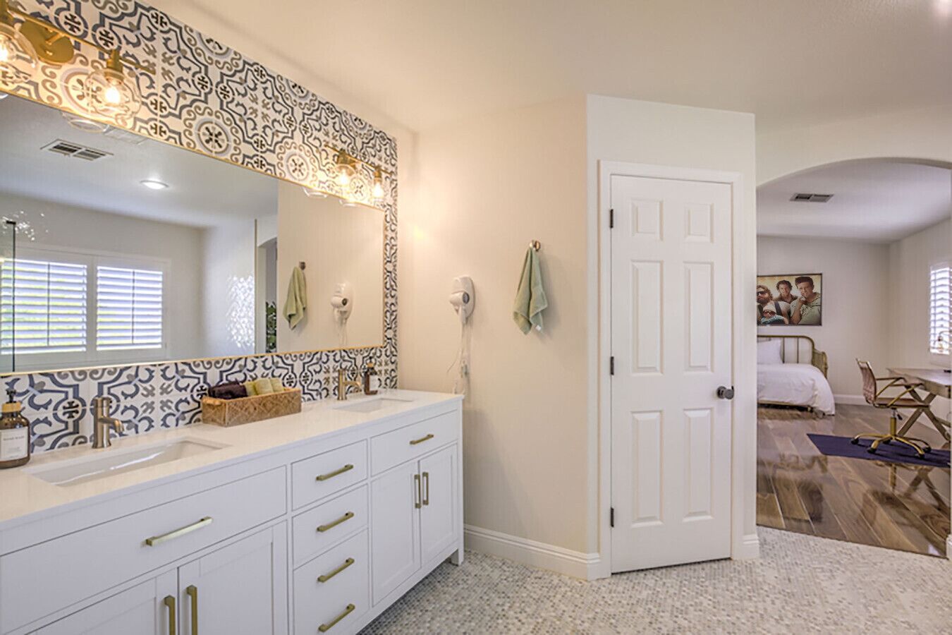 Un baño moderno con un espejo grande, tocador blanco y salpicadero decorativo.