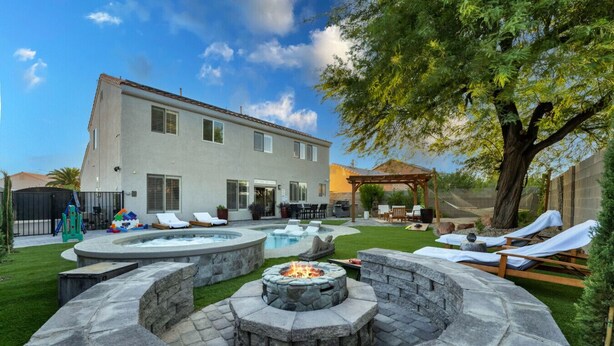 A backyard with a hot tub, fire pit, and lounge chairs. - Buddha Estate#4 - Great neighborhood, Sparkling pool and Hot tub, EV Charger, Games (Henderson)