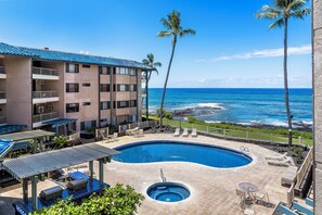 A hotel with a pool, outdoor seating, and a view of the ocean. - NEW, BEACHFRONT KONA REEF ALOHA CONDO WITH A/C (Kailua-Kona)