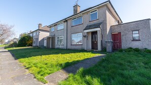 A two-story residential building with a front entrance, a red door, and a small front garden. - Melrose 1 (Lancaster)