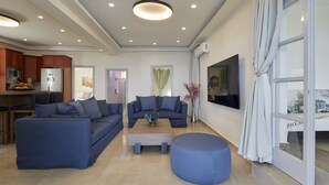 Un salon moderne avec deux canapés, une table basse et un pouf rond.