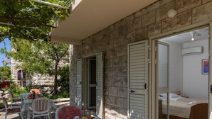 A room with a bed, a table with a basket of fruit, and a chair. - Begovic Guest House - Private Twin Room (Dubrovnik)