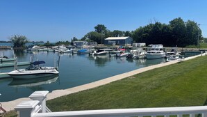 A marina with various boats docked, a grassy area, and a building in the background. - Middle Bass Island Luxury Rental (Middle Bass)