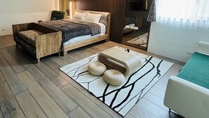 A modern bedroom with a bed, a wooden bench, a small table, and a mirror. - Seth Spring B&B (Datong)