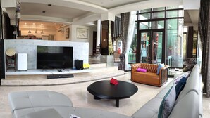 A spacious living room with a large flat-screen TV, comfortable seating, and a fireplace. - Seth Spring B&B (Datong)