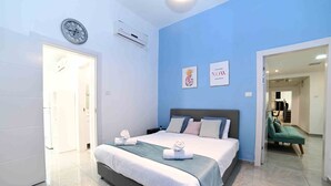 A modern bedroom with a large bed, a clock on the wall, and two framed pictures. - Yalarent Villa Viviana with private pool (Migdal)