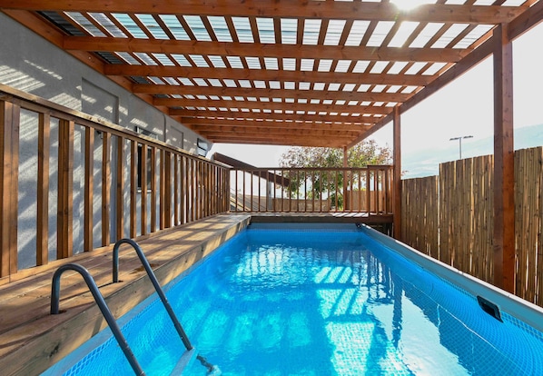 An indoor swimming pool with wooden railings and a wooden pergola overhead. - Yalarent Villa Viviana with private pool (Migdal)