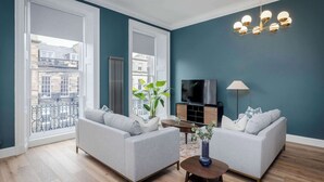 A living room with two sofas, a TV, a lamp, and a plant.